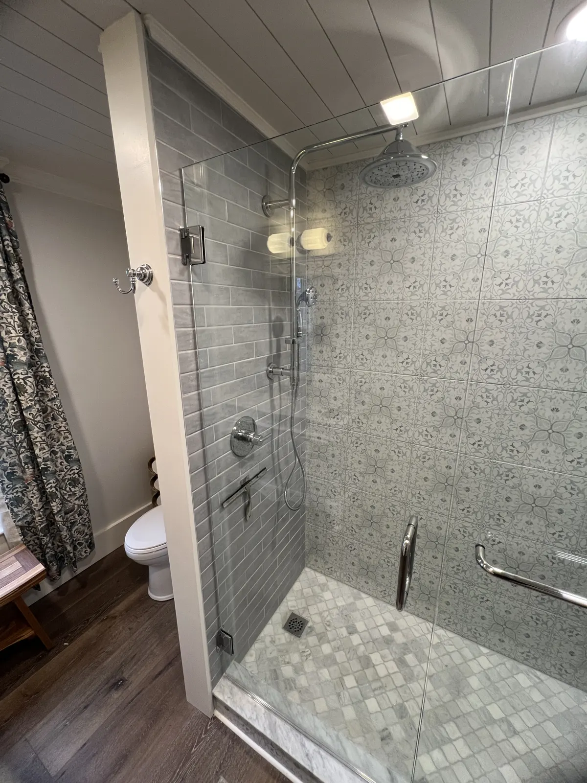 Frameless glass shower with patterned gray tile