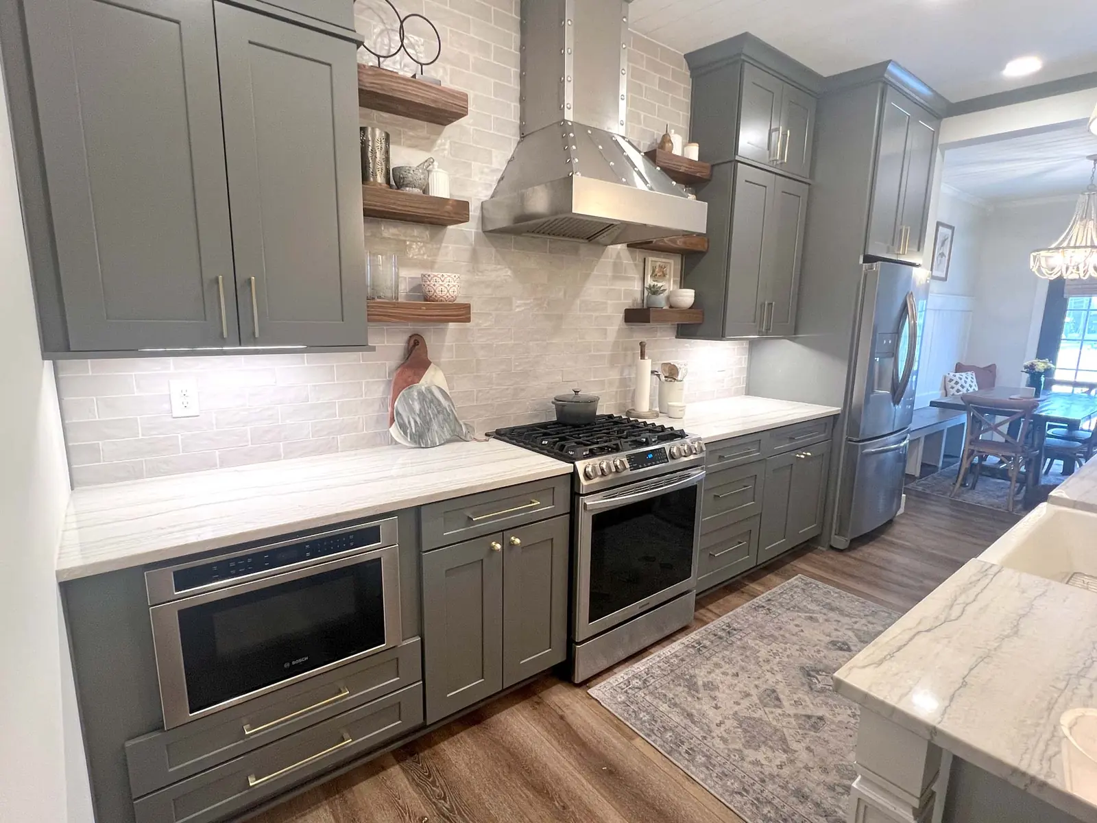 Gray kitchen with open wood shelves and a stainless range hood