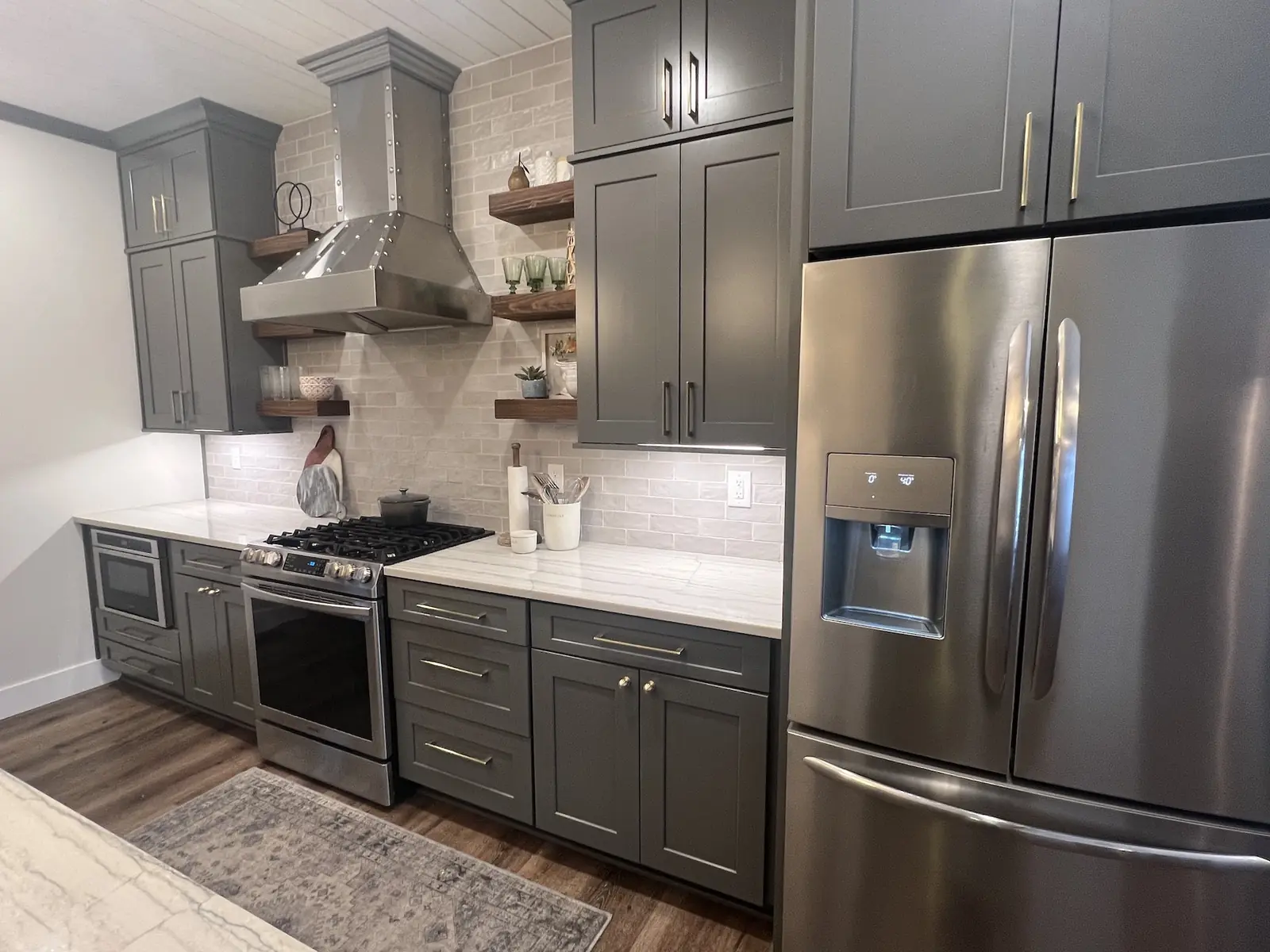 Gray kitchen with stainless range, hood and refrigerator