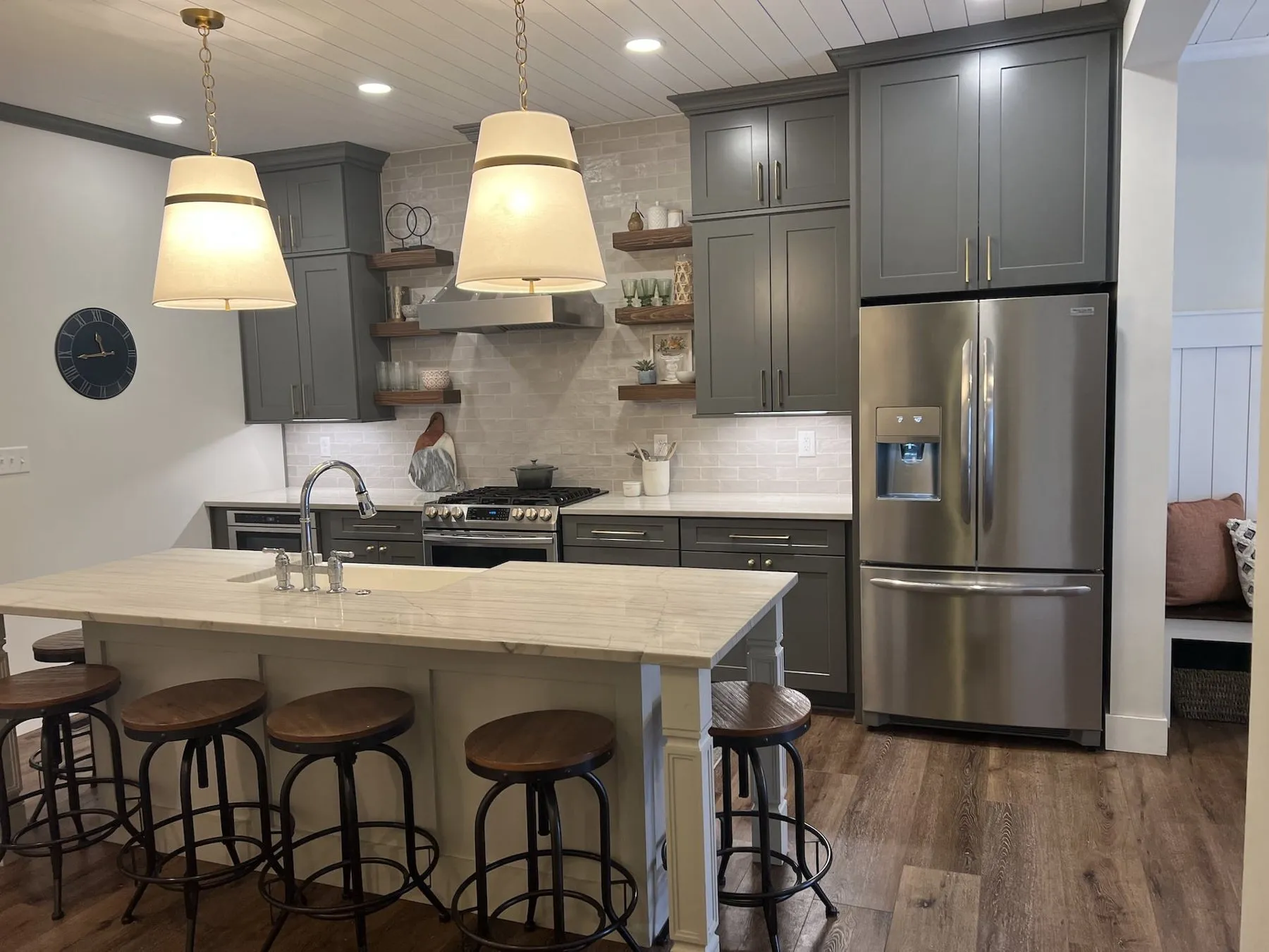 Kitchen island with stools under woven pendant lights
