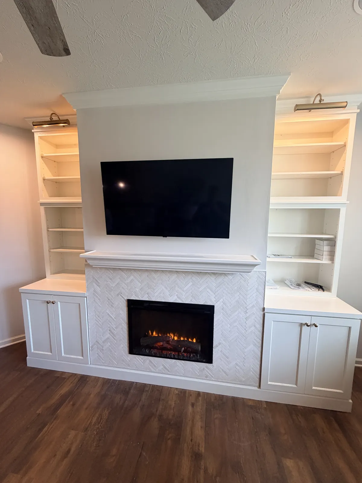 Electric fireplace in a herringbone tile surround with a floating mantel