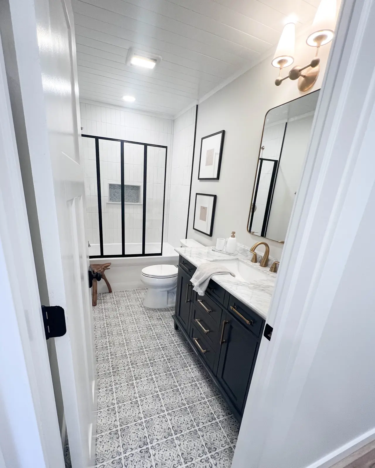 Bathroom with a navy vanity and a black steel-frame shower