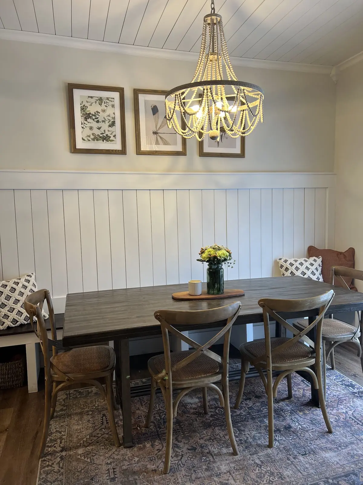 Dining room with shiplap walls and a beaded chandelier