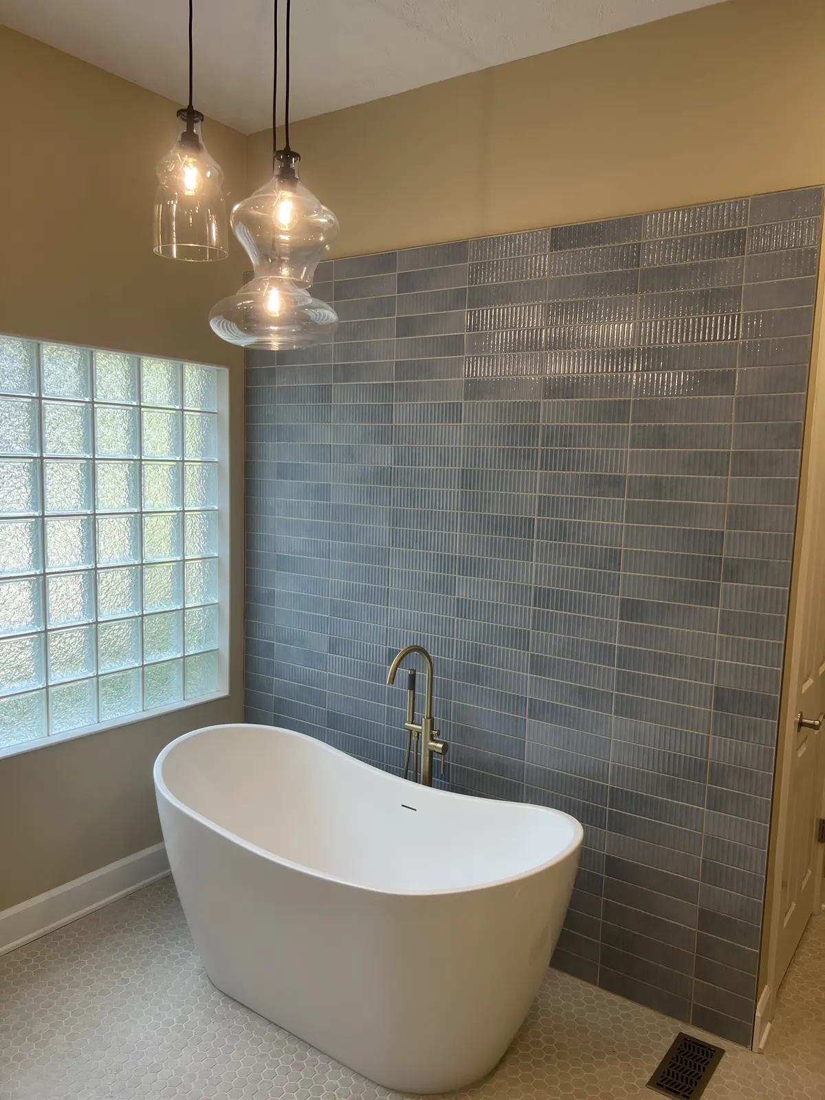 Primary bathroom remodel with a freestanding tub, blue tile wall and glass block window in Lebanon, Indiana