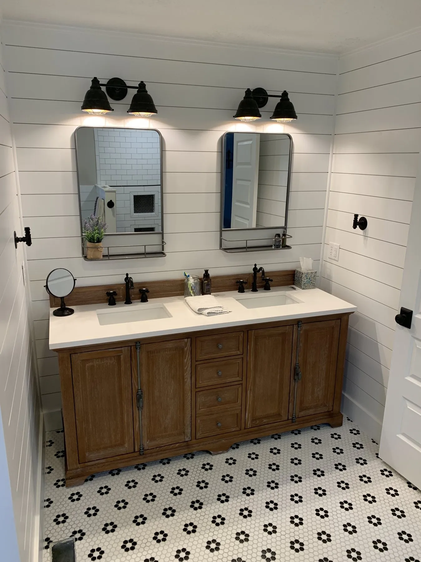 Wood double vanity with black mirrors, shiplap walls and hex mosaic floor