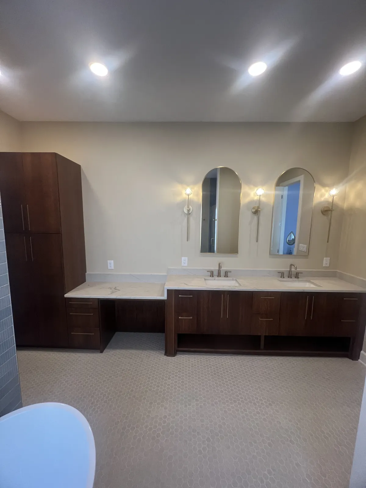 Walnut vanity with a lower makeup counter and tall linen tower