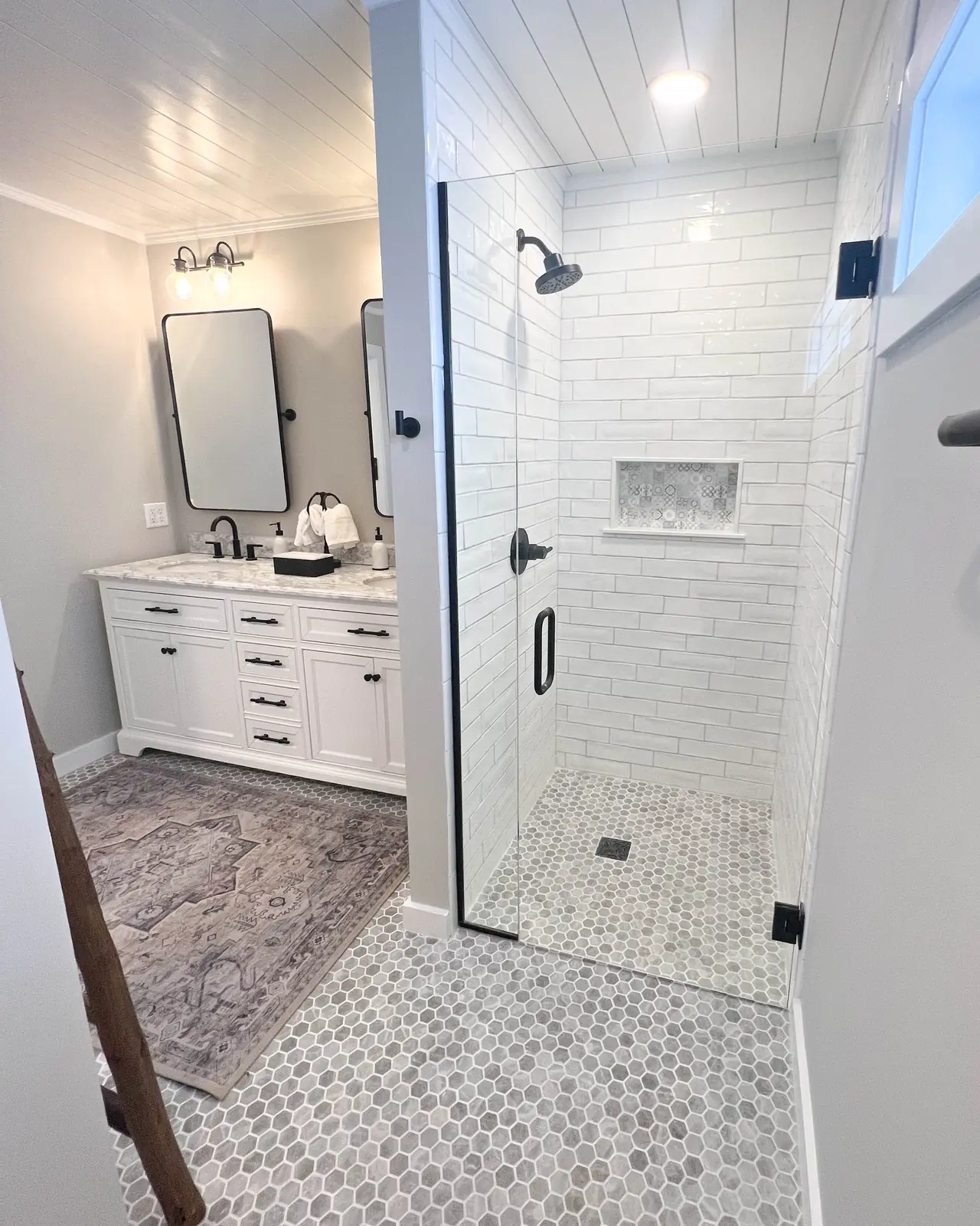 White bathroom with a walk-in shower, tiled niche and mosaic floor