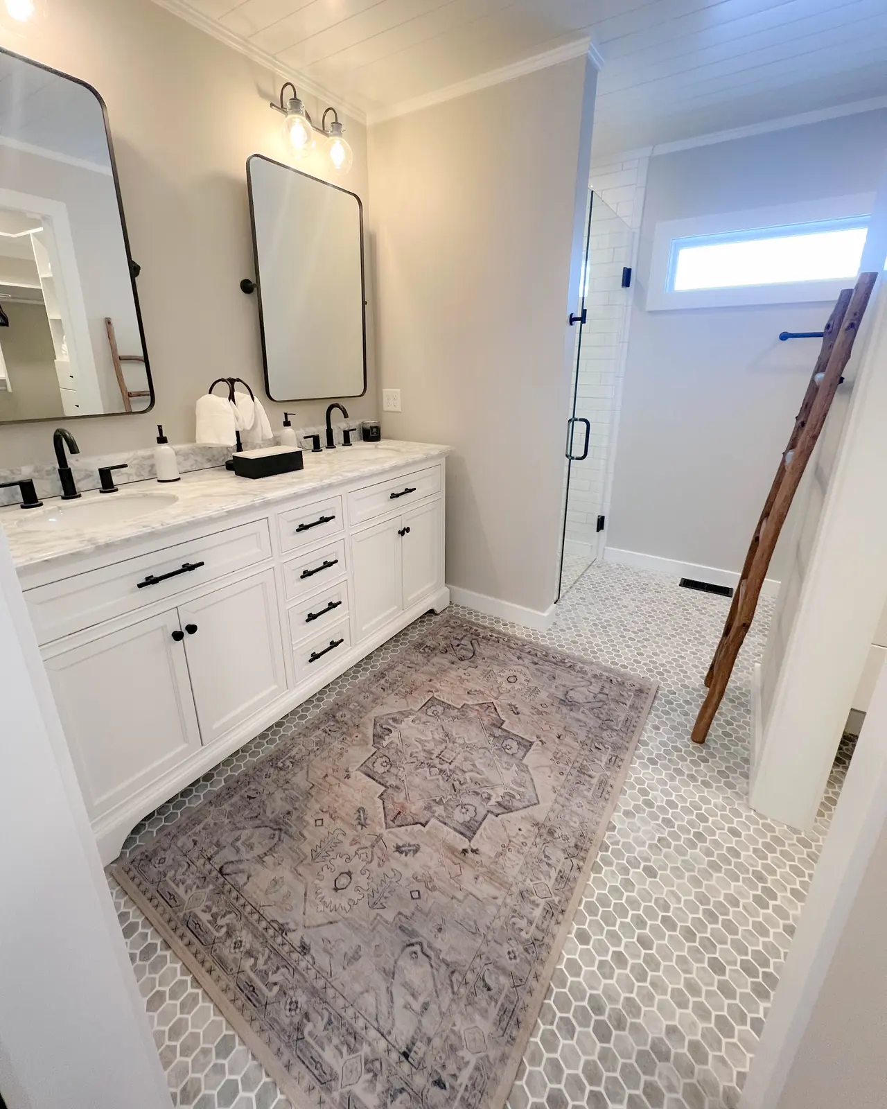 White double vanity with black fixtures and a patterned rug